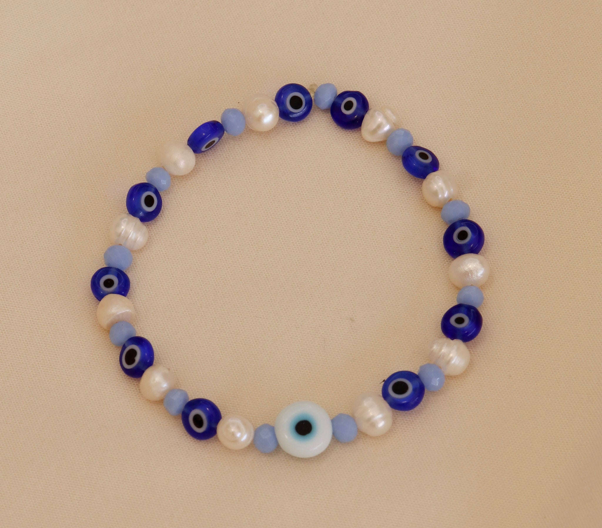 Pulsera Ojos azules con perlas blancas